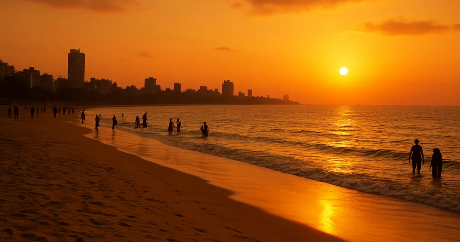 Silhouettes gather along a Mumbai beach as the sun sets.
